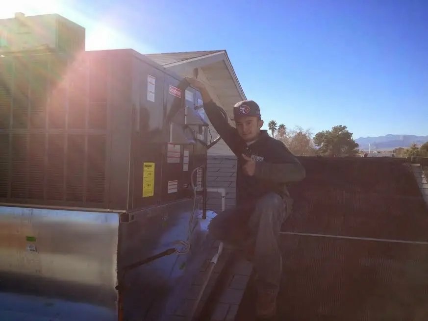 HVAC technician performing Heat Pump Repair on a rooftop unit in Dry Run